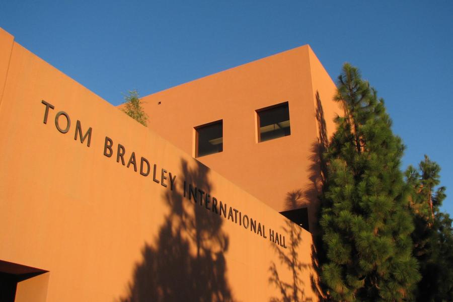 Main entrance of Bradley Hall painted a salmon orange with contrasting evergreen landscaping